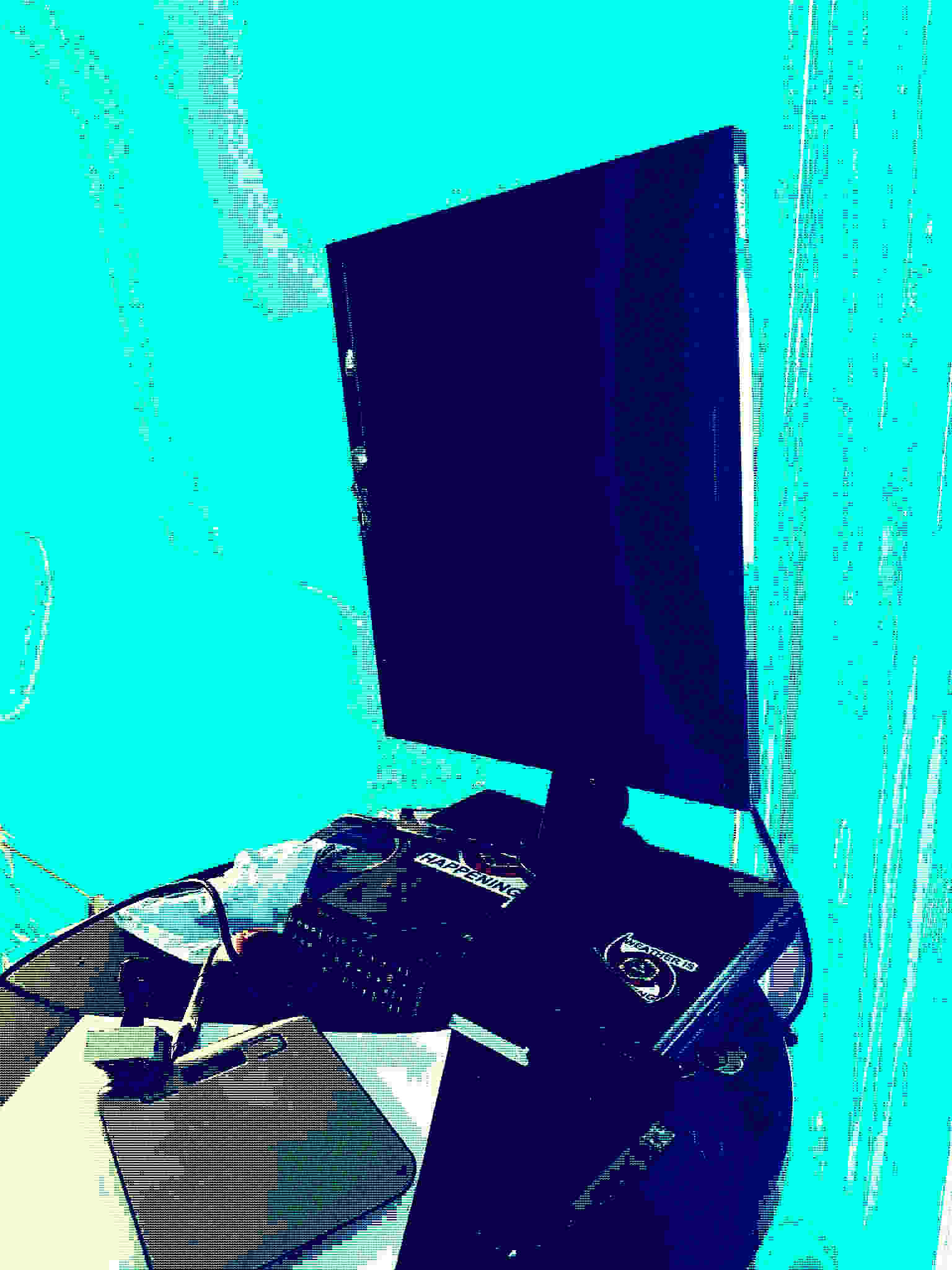 A SCENE FROM THE WEATHER LAIR OF A OLD MONITOR FROM 2008 ON A TABLE W/ OTHER CRAP